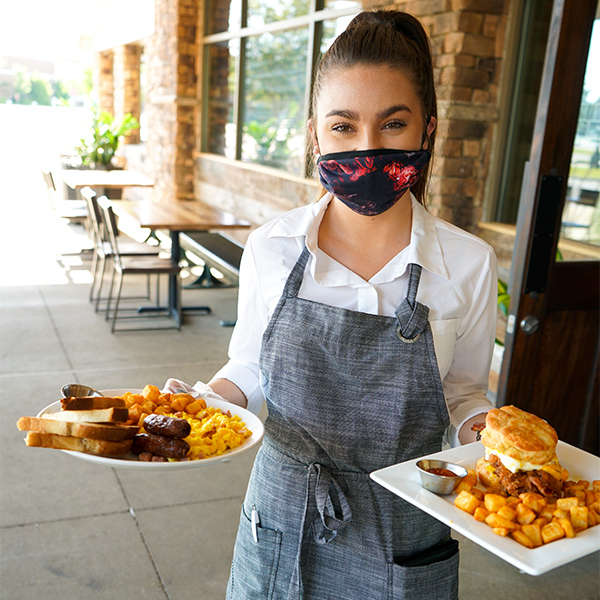 Bakers Crust Employee carrying food plate wearing face masks